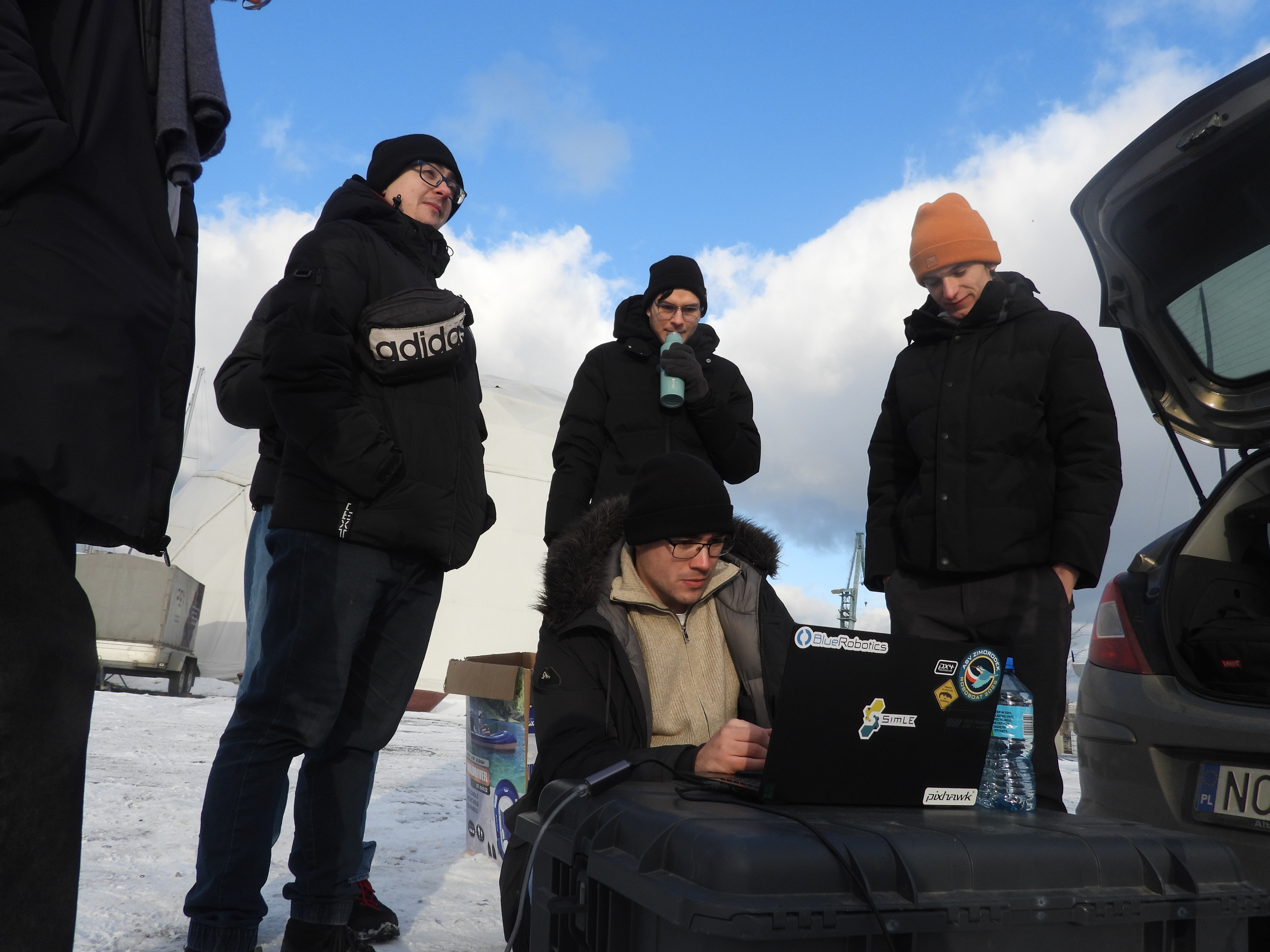Team checking laptop in snow